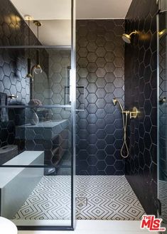 a bathroom with black and white tiles on the walls