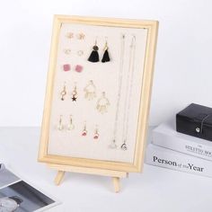 a wooden frame holds several pairs of earrings