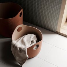 two clay pots sitting on the floor next to each other