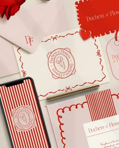 red and white wedding stationery with envelopes, flowers, and hearts on the table