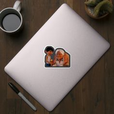 an image of two people in the middle of a table next to a cup of coffee