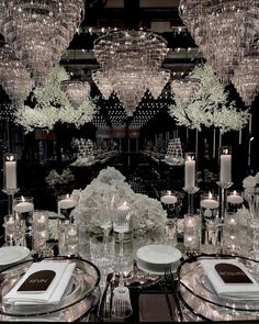 a table set with plates, silverware and crystal chandeliers