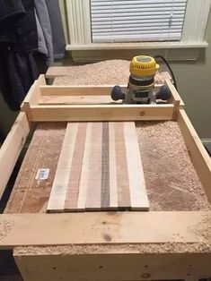 a workbench made out of wood with a sanding board on top and a drill bit in the middle