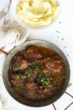 a pot filled with meat and mashed potatoes next to a bowl of mashed potatoes