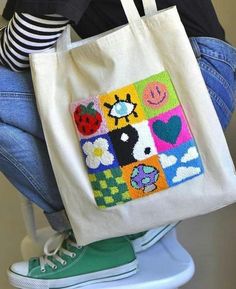 a woman is sitting on a stool with a tote bag