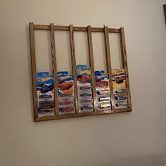 there is a wooden rack with hot wheels on it