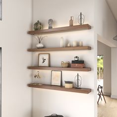 two open shelves on the wall with pictures and vases in them, along with other items