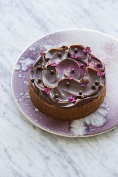 a heart shaped chocolate cake sitting on top of a pink plate