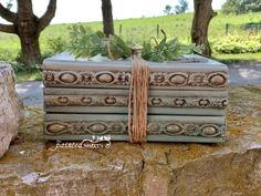 an old book wrapped in twine and tied up with a string, sitting on top of a rock