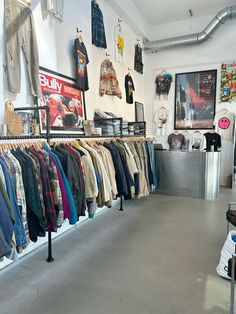 a clothing store filled with lots of different types of jackets and shirts hanging on the wall