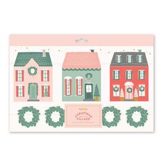 a card with houses and wreaths on the front, in pastel pink and green