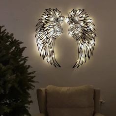 a living room filled with furniture and a lighted angel wings wall art piece on the wall