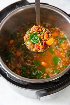 a ladle full of soup being held by a spoon