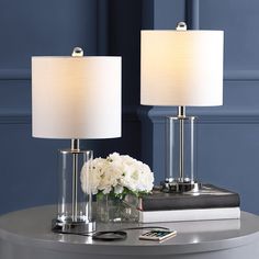 two lamps sitting on top of a table next to a vase with flowers in it