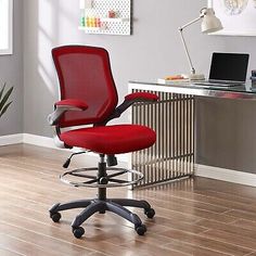 a red office chair sitting in front of a desk with a laptop computer on it