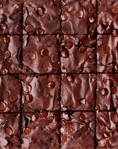 chocolate brownies are arranged in rows on top of each other with chocolate chips scattered around them