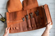 a leather tool roll with six wrenches in it and a pair of pliers