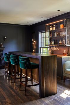 a bar with stools in front of it and shelves on the wall behind it