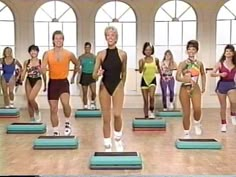 a group of women standing on top of blue and green exercise mats