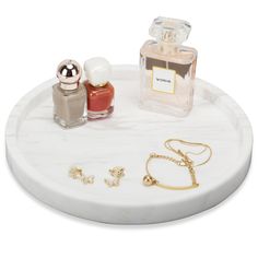 a marble tray with two perfume bottles and gold accessories