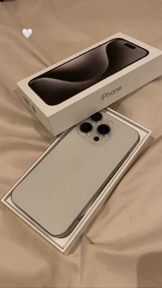 an iphone box sitting on top of a bed next to it's opened packaging