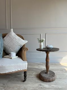 a living room with a couch, chair and table on the floor in front of a wall