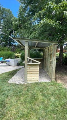 a small wooden shelter in the middle of a yard