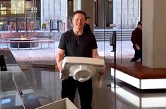 a man standing in an empty building holding a piece of equipment