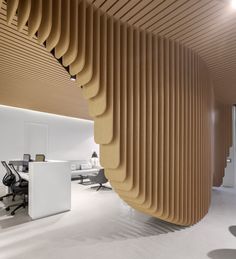 two photographs of an office with wooden slats on the ceiling and desks in the background