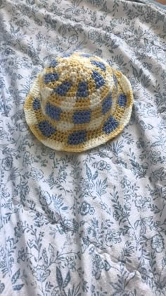 a yellow and blue hat laying on top of a bed