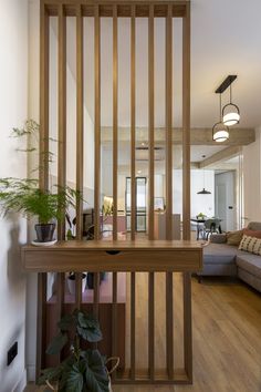 a living room filled with furniture next to a wooden floor covered in potted plants