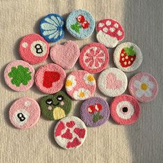 a pile of different types of buttons on a white table cloth with a person's shadow in the background