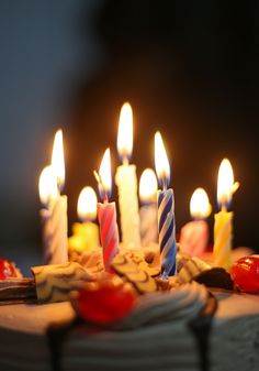 a birthday cake with many lit candles on it