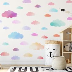 a child's room with clouds painted on the wall and a toy storage bin