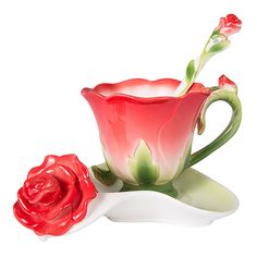 a red rose sitting on top of a saucer next to a white cup and spoon