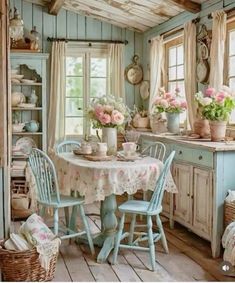 an old fashioned kitchen with blue cabinets and tables