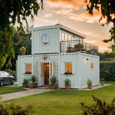 a house made out of shipping containers with a car parked in the driveway next to it