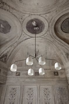 a chandelier hangs from the ceiling in an ornately decorated room with painted ceilings