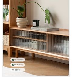 a wooden shelf with some plants on top of it and a bookcase in the background