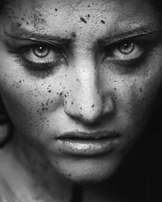 a black and white photo of a woman with freckles on her face