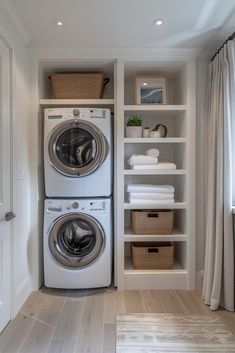 a washer and dryer in a small room with white shelves on the wall