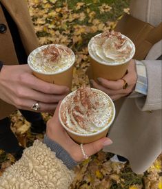 Three friends are in a circle and holding up cups of hot coffee with whipped cream on top. Gilmore Girl, Fall Drinks