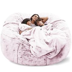 two women laying in a bean bag chair with a blanket on the back and one woman hugging her head