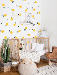 a baby's room with lemons on the wall and a crib next to it