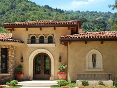 the front entrance to a home with flowers and shrubs