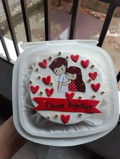 a cake decorated with two people and hearts