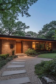 a modern home with stone steps leading to the front door and entry way, surrounded by trees