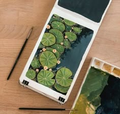 an artist's palette and water lilies on a wooden table