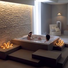 two people in a bathtub surrounded by candles