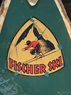 a green and yellow sign with a man skiing on it's skis that says fisher ski